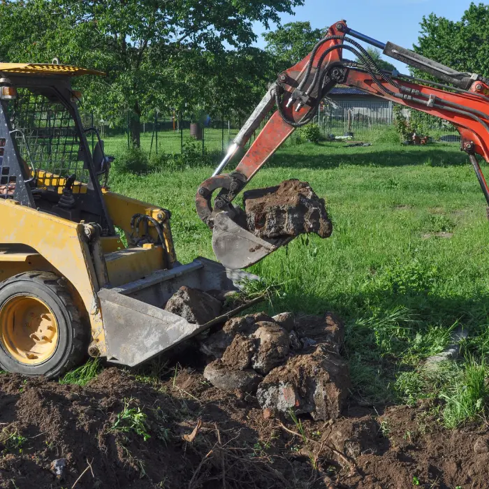 Chargeuse en intervention sur un terrain engazonné