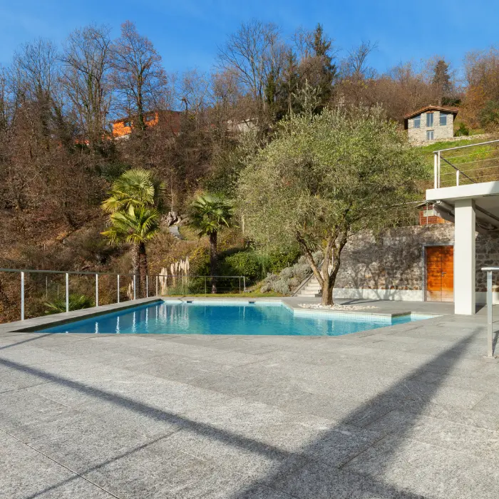 Piscine et plage en béton bordée de palmiers